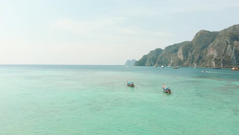 abundantes aguas turquesas exóticas que se extienden más allá del horizonte rodeado por el paraíso de la isla de ko phi phi don en tailandia - tiro panorámico bajo aéreo