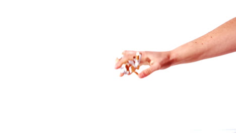 feminine hand throwing a bung of crushed cigarettes on the floor