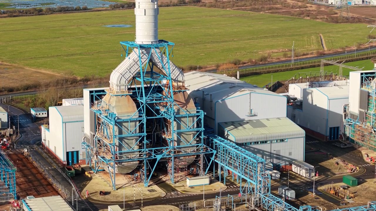 Toma aérea de revelación ascendente que muestra la masiva central eléctrica de gas de South Humber Bank en el paisaje llano de Lincolnshire, Reino Unido.