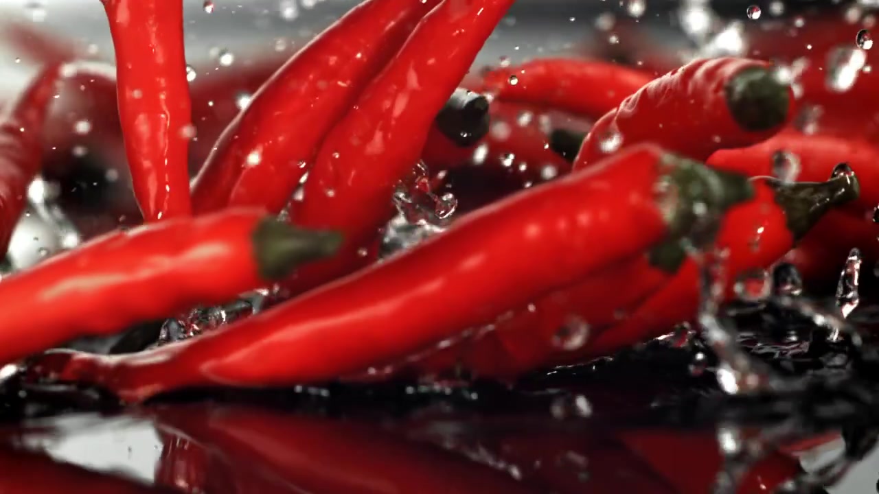 Cabai Merah Cerah Jatuh ke Dalam Air dengan Percikan.