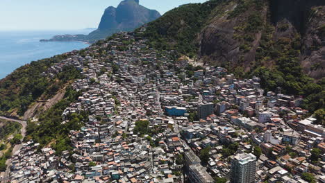 aerial reveal of favela vidigal's colourful houses with mountains in rio de janeiro