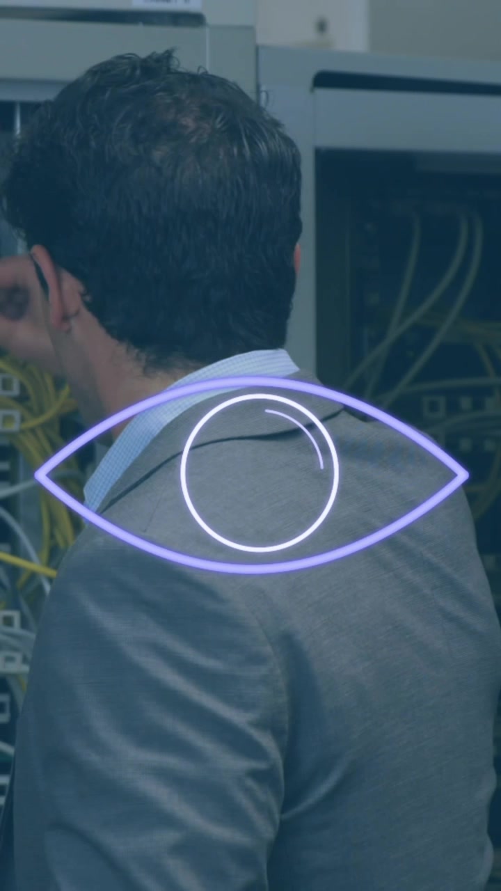 Animation of violet shapes and eye over back of caucasian man working with servers