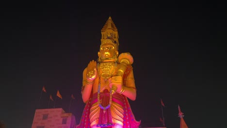 vista nocturna de la mayor estatua dorada del señor hanuman frente al templo en rajarhat en kolkata, india