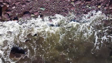 Luftaufnahme-Von-Oben-Auf-Die-Wellen,-Die-An-Einem-Felsigen-Strand-Brechen,-4k