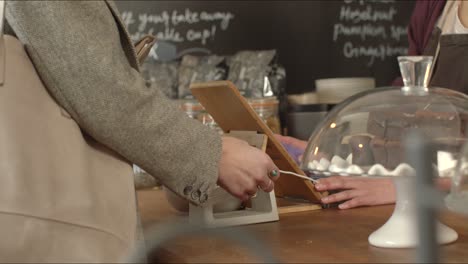 Woman-Using-Contactless-Payment-in-Cafe