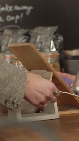 woman using contactless payment in cafe