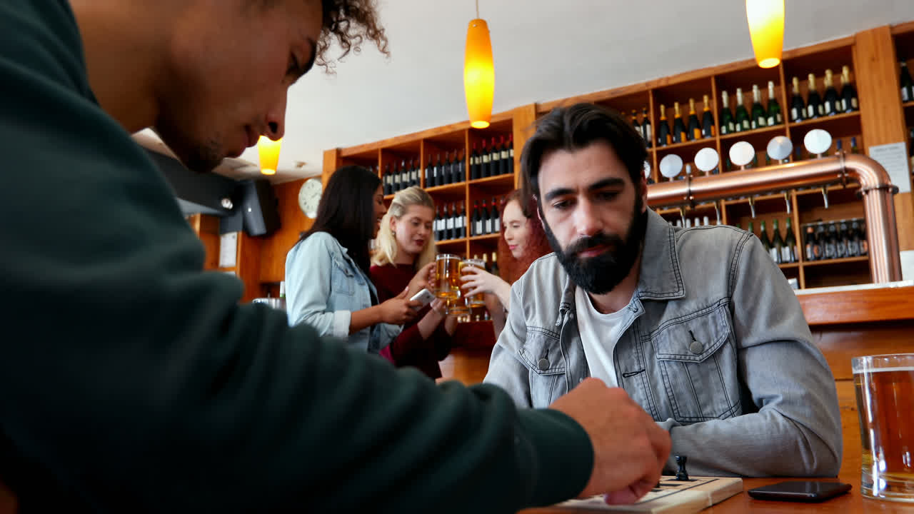 amigos jugando al ajedrez en el bar 4k