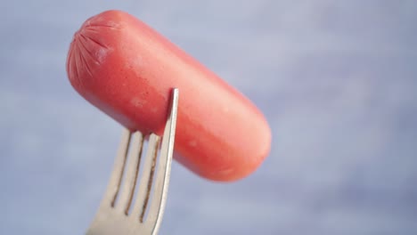 pink sausage on a fork