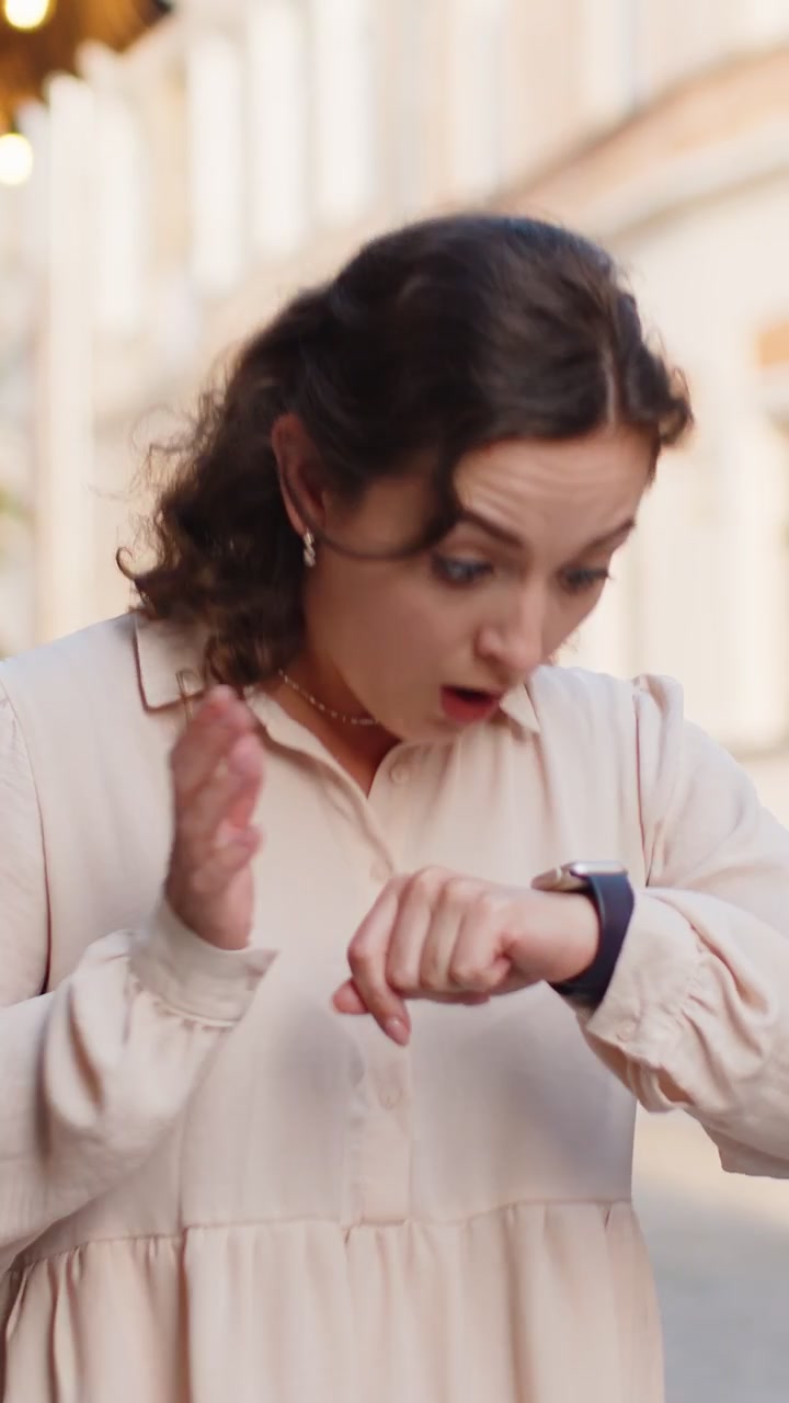 Scared woman worrying to be punctual with anxiety checking time on watch running late to work