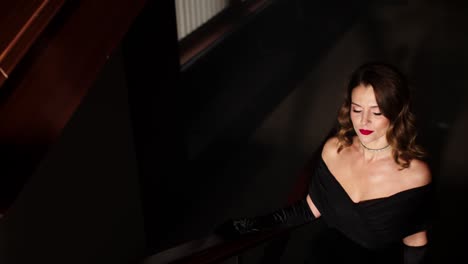 a mysterious and beautiful woman in an evening dress and high heels climbs the stairs into the smoky room
