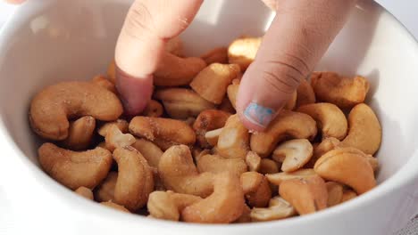 child eating cashews from a bowl