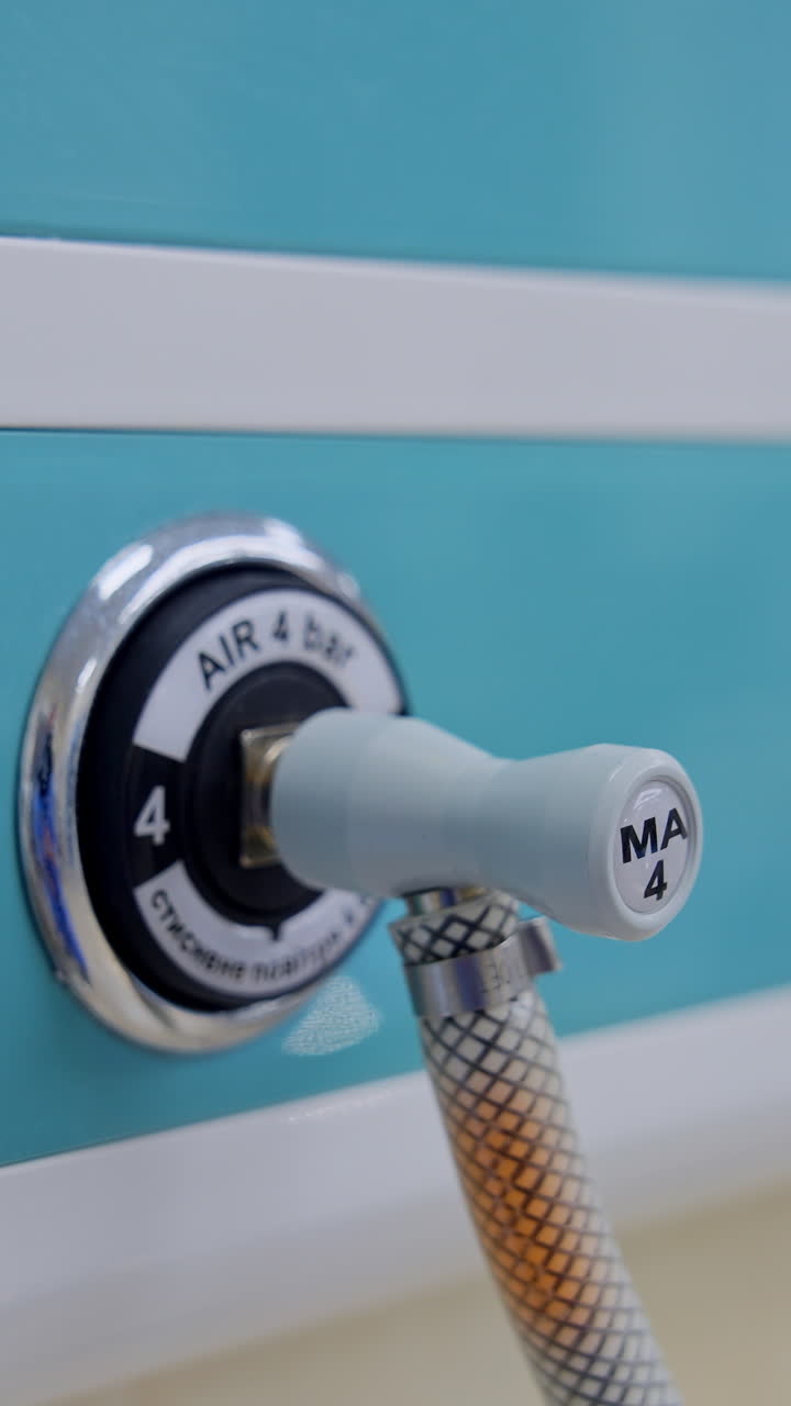 Air supplier connected to the apparatus through the tube. Slots in the panel on the wall of modern surgical theatre. Close up. Vertical video
