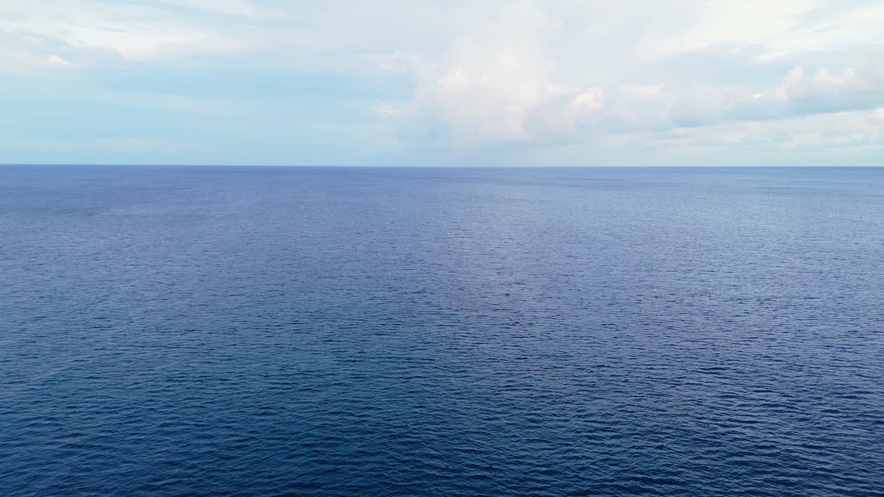 Peaceful drone dolly over small boat on calm turquoise Caribbean waters, capturing the clear and vibrant ocean surface