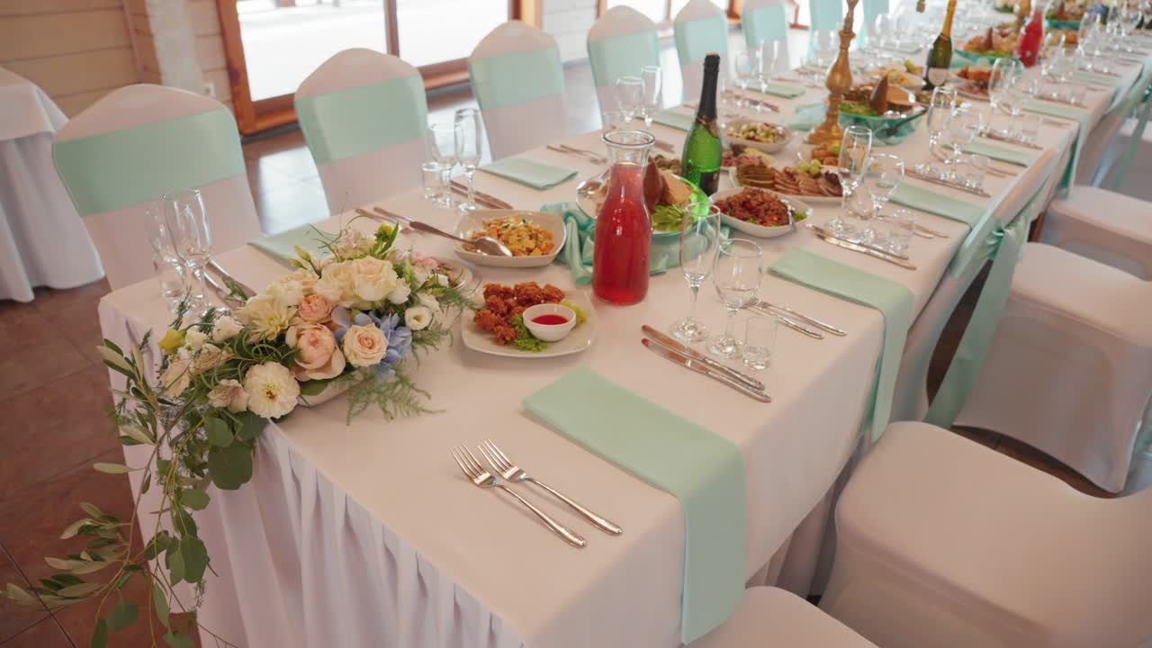 A beautifully arranged banquet table set for a wedding reception, adorned with elegant floral arrangements, exquisite tableware, and gourmet dishes, bathed in soft natural light