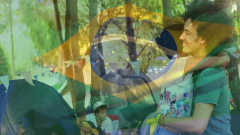 disfrutando de acampar al aire libre, gente con la animación de la bandera brasileña en el fondo