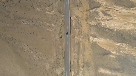 Conducción-De-Automóviles-En-Una-Carretera-En-Lanzarote,-España-Con-Arena-A-Ambos-Lados-De-La-Carretera