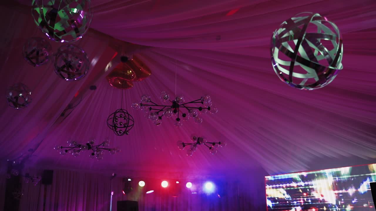 Night ceiling with balls and lights. Colorful sphere with lights shimmering in the nightclub. Lasers spotlights over concert hall.