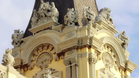 historical building with tall tower and statues. stone facade building