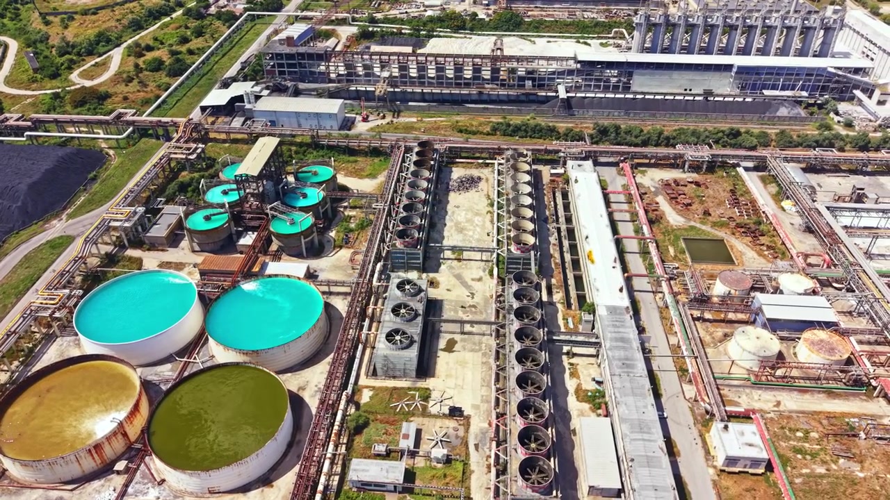 Factory site with large tanks and cooling systems during daytime in an industrial area