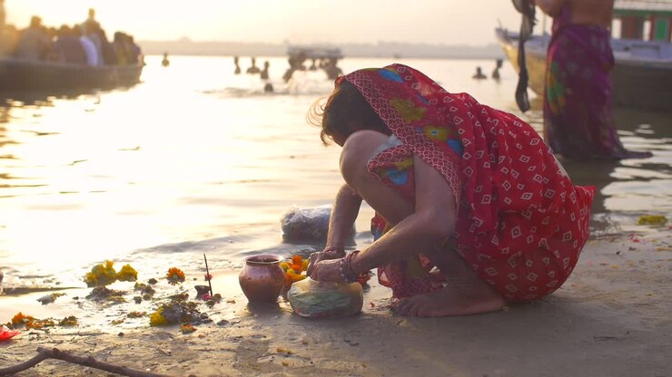 Femme indienne accroupie triant des fleurs de souci