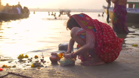 crouching indian woman sorts marigold flowers