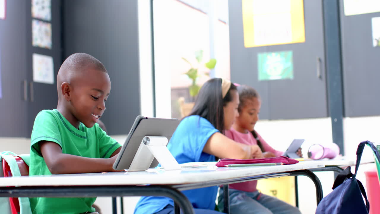 A scuola, bambini che usano tablet e lavorano insieme in classe