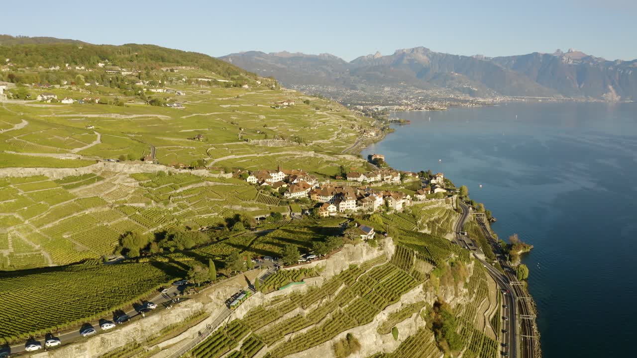 Panoramica aerea ad alta quota di un tipico villaggio nei vigneti di Lavaux, Svizzera, con luce al tramonto e colori autunnali.