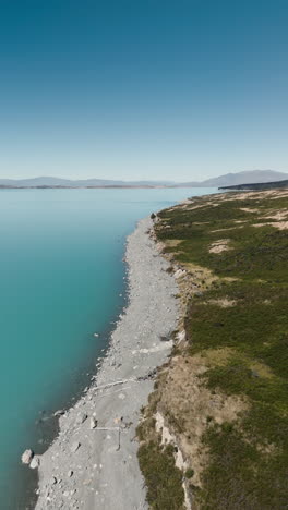 aerial view of turquoise lake with rocky shoreline and mountains