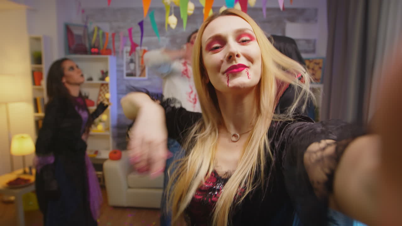 pov de una joven disfrazada de hechicera inventando amigos en una fiesta de halloween