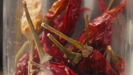 Close-up of dry red hot chilli peppers in glass can. Preservation of vegetables in glass jars. Hot spices for food adding