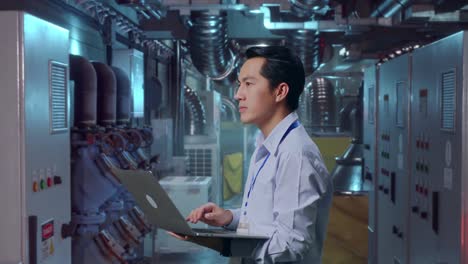 engineer working on a laptop in a factory