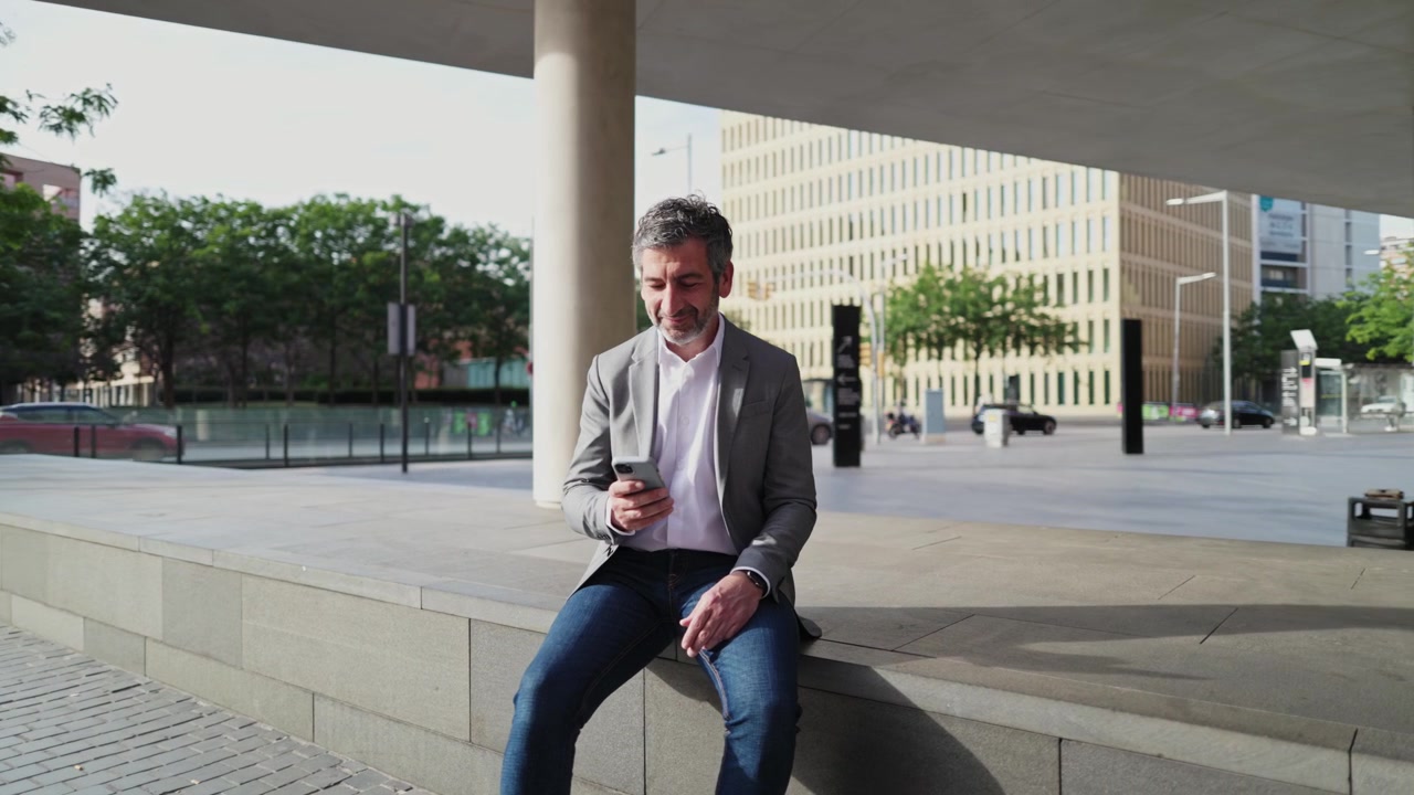 Smiling Man in Business Casual Attire Using Smartphone in City
