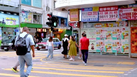 people crossing street at a busy intersection