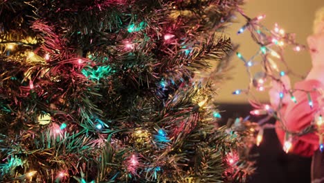 young caucasian kid helping to decorate christmas tree with christmas light, close up