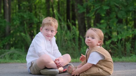two young boys are sitting comfortably on the ground talking to each other two young boys are sitting on the soft ground and engaging in a lively conversation with each other enjoying their time together