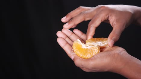 hands holding a sliced orange