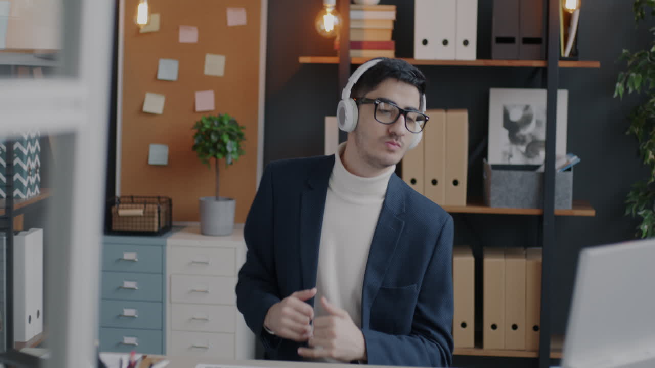 Young Man Listening to Music in Office
