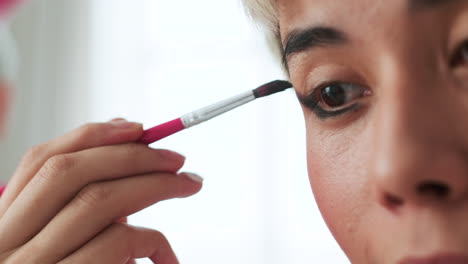 persona asiática que usa maquillaje en casa