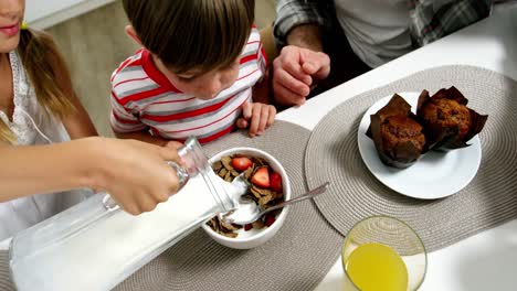 Girl-pouring-milk-to-cereal-bowl-