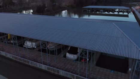 Aerial-footage-slowly-rising-above-the-boat-docks-to-see-the-lake-and-land-behind-it