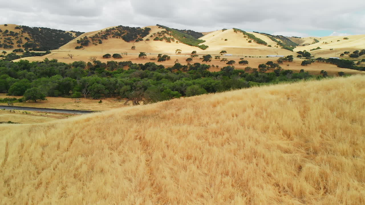 antena de la carretera en el paisaje de colinas de pasto seco.