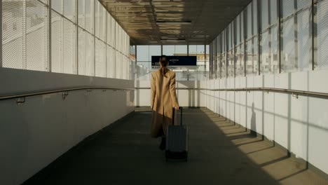 woman walking through an empty train station tunnel