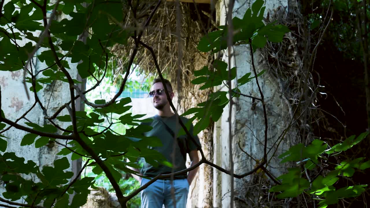 hombre explorando un jardín en ruinas