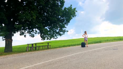 young girl tourist with bag waiting in suburb countryside road.