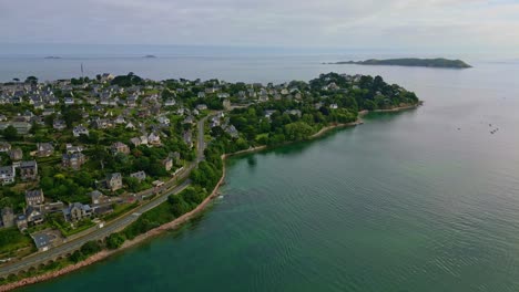 drone moves forward toward the perros-guirec coastline, showing seaside houses, vegetation and the sea