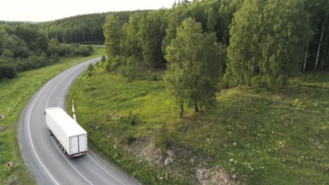 truck on a winding road through a forest