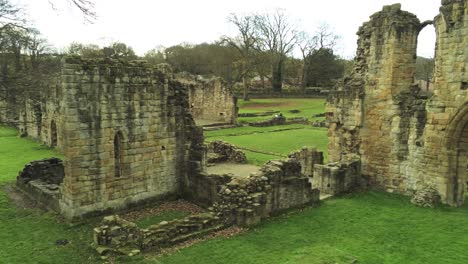 basingwerk abbey landmark medieval abandoned welsh ruins aerial view low angle orbit right