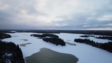 Eine-Luftaufnahme-Einer-Drohne-Von-Einem-Zugefrorenen,-Schneebedeckten-See-Und-Einer-Flussinsel-In-Der-Arktis-Im-Norden-Manitobas,-Kanada