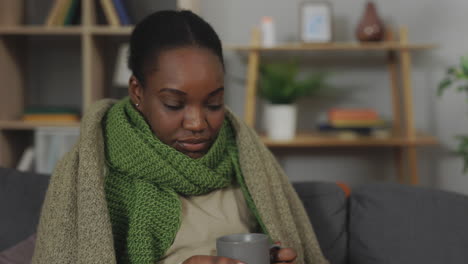 woman feeling ill drinking hot beverage