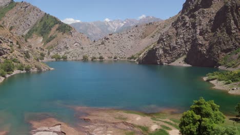 jade-colored waterscape of urungach lake with a view of rocky mountains in uzbekistan